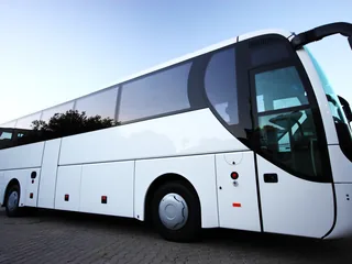 Reisebus in der Seitenansicht bei Dämmerung